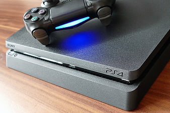 PlayStation 4 Console and Controller on Wooden Surface