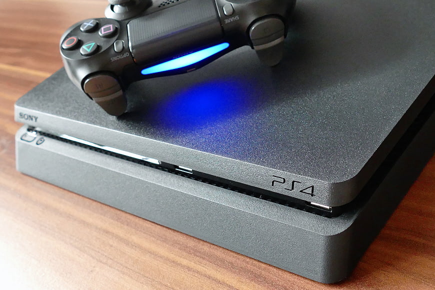 PlayStation 4 Console and Controller on Wooden Surface