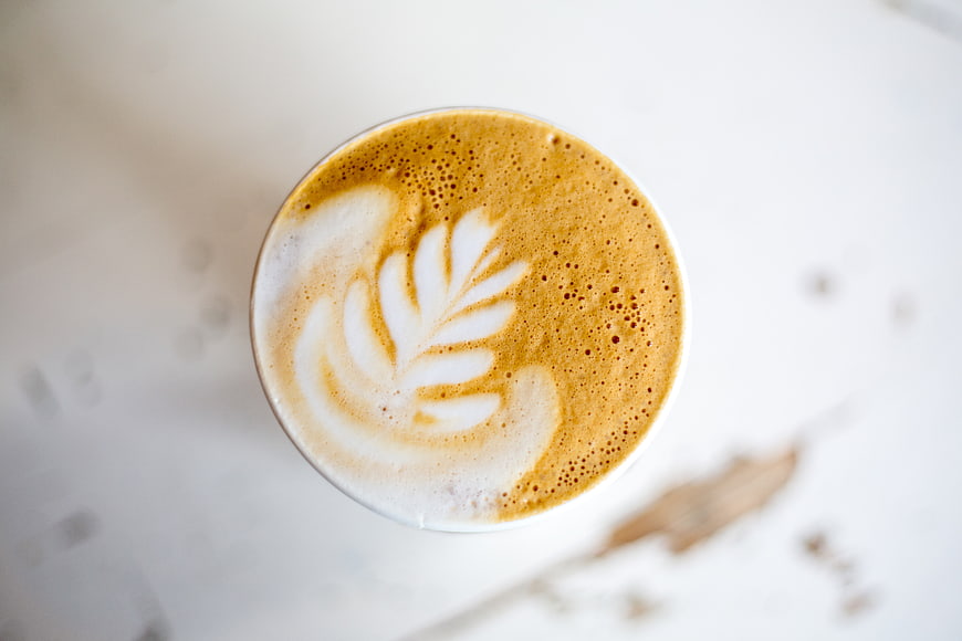 Top View of Cappuccino with Leaf Latte Art on White Table