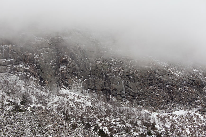 Misty Rocky Mountain Cliff in Winter Snow