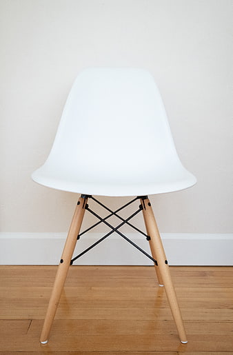 Minimalist white modern chair on wooden floor