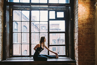 Woman stretching on large industrial window sill