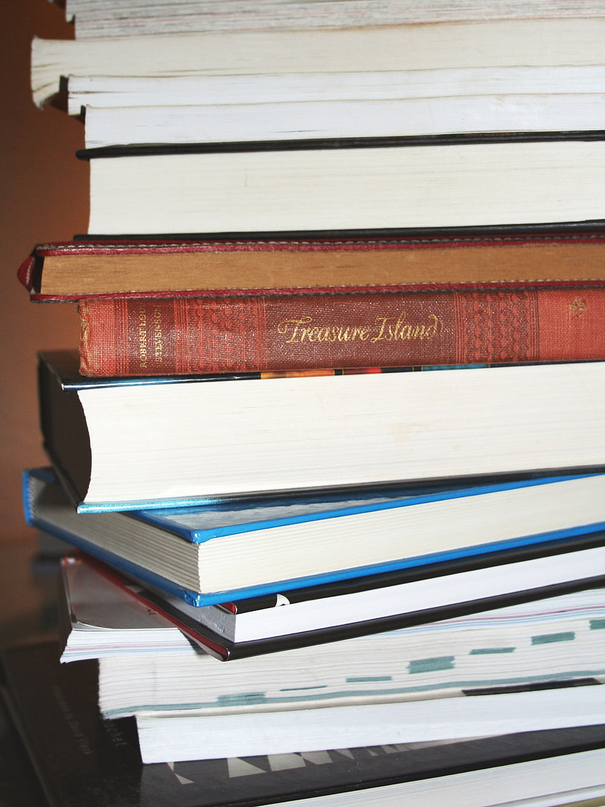 Stack of vintage and modern books with Treasure Island spine