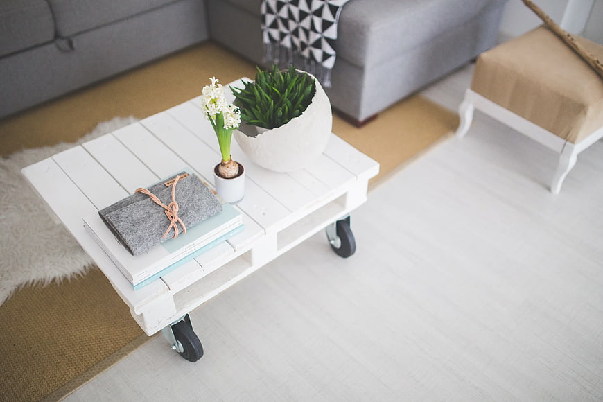 White pallet coffee table with plants and books