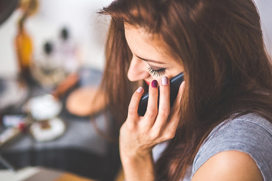 Close-up of woman talking on smartphone with colorful nails