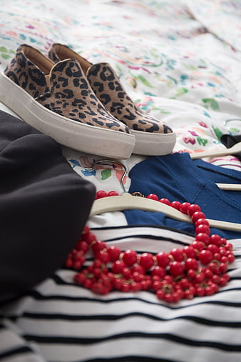 Leopard print sneakers and red beaded necklace on striped shirt