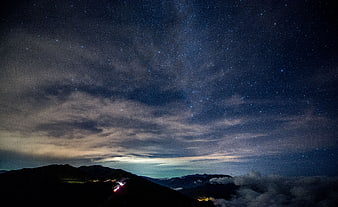 Starry Night Sky Over Mountain Peaks with Clouds
