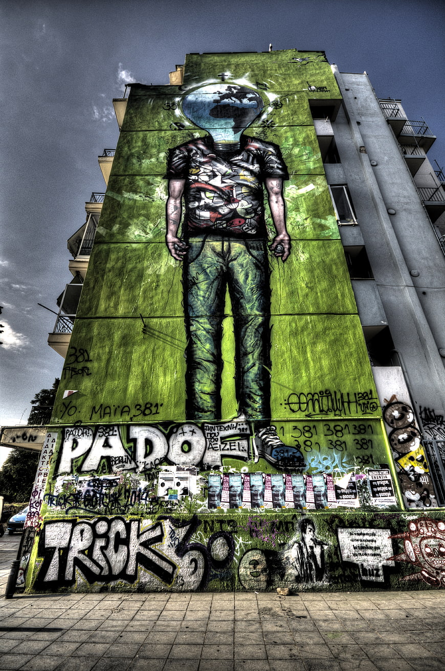 Large Green Graffiti Mural of Headless Figure on Urban Building