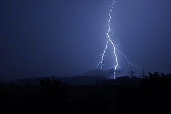 Dramatic Lightning Strike Over Dark Rural Landscape at Night
