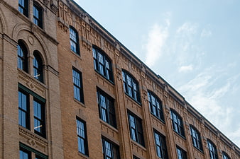 Low angle view of historic brick building facade with arched windows