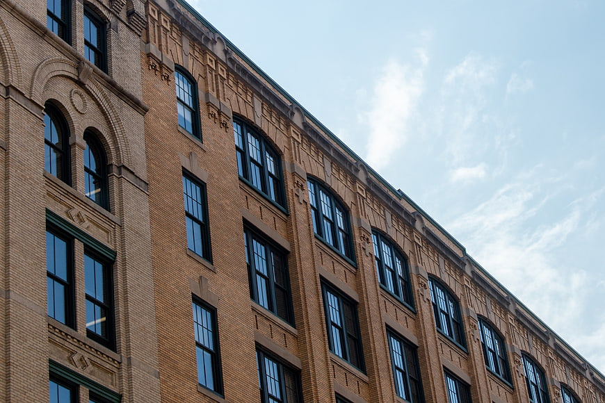Low angle view of historic brick building facade with arched windows