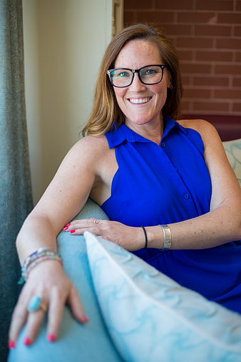 Smiling woman with glasses in blue sleeveless top
