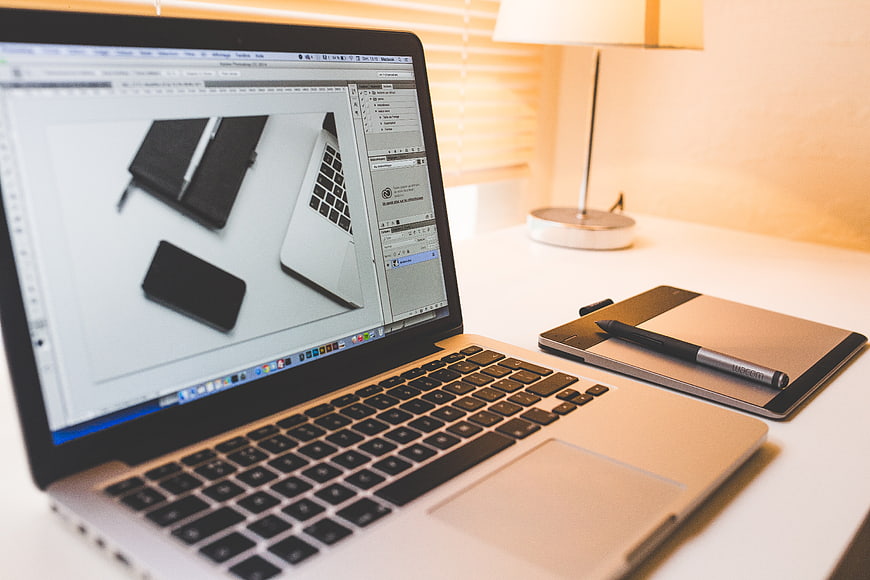Laptop and Graphics Tablet on Desk with Warm Lamp Light
