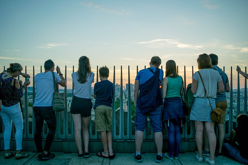 Group of Tourists Watching Sunset Over City Skyline
