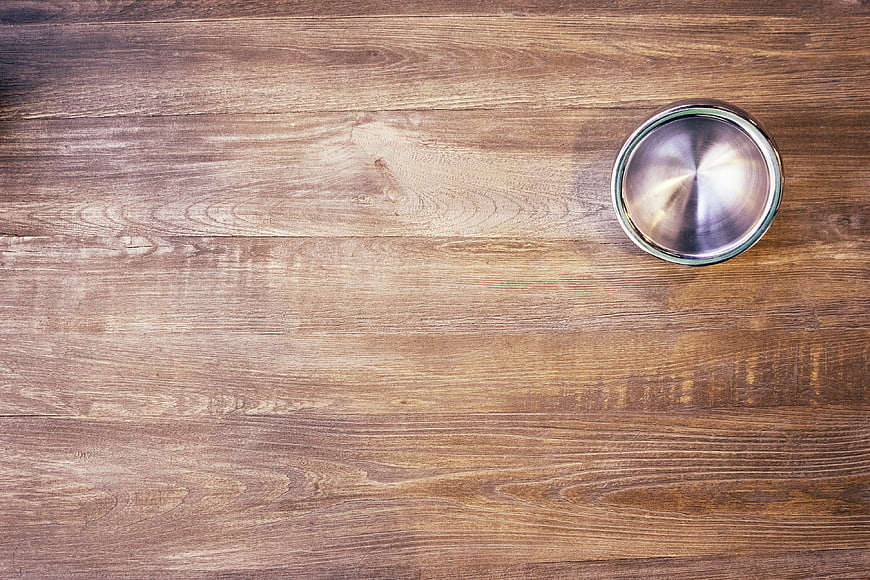 Empty stainless steel bowl on rustic wooden table background