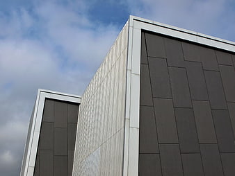 Modern architectural detail with geometric facade and sky