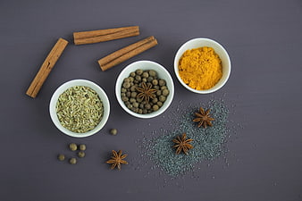 Flat lay of cinnamon, turmeric, fennel, and spices on dark background