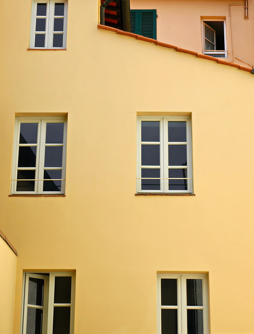 Yellow building facade with white windows and architectural details