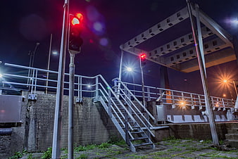Red Traffic Light on Industrial Bridge at Night