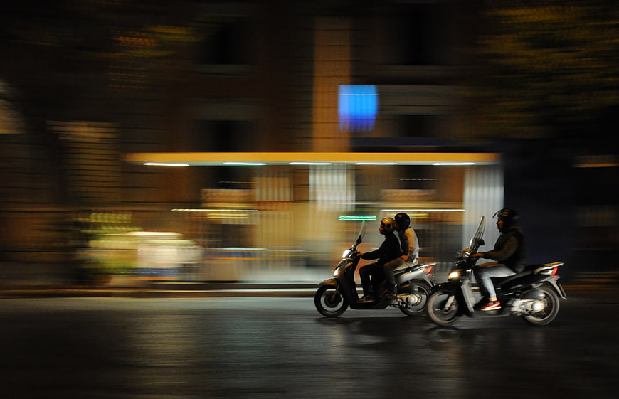 Night Panning Shot of Scooters on Urban Street