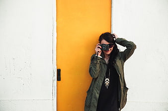 Woman with Camera in Front of Yellow Door