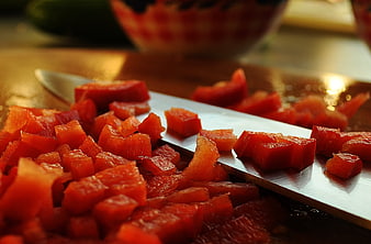 Close-up of diced red peppers on a kitchen knife