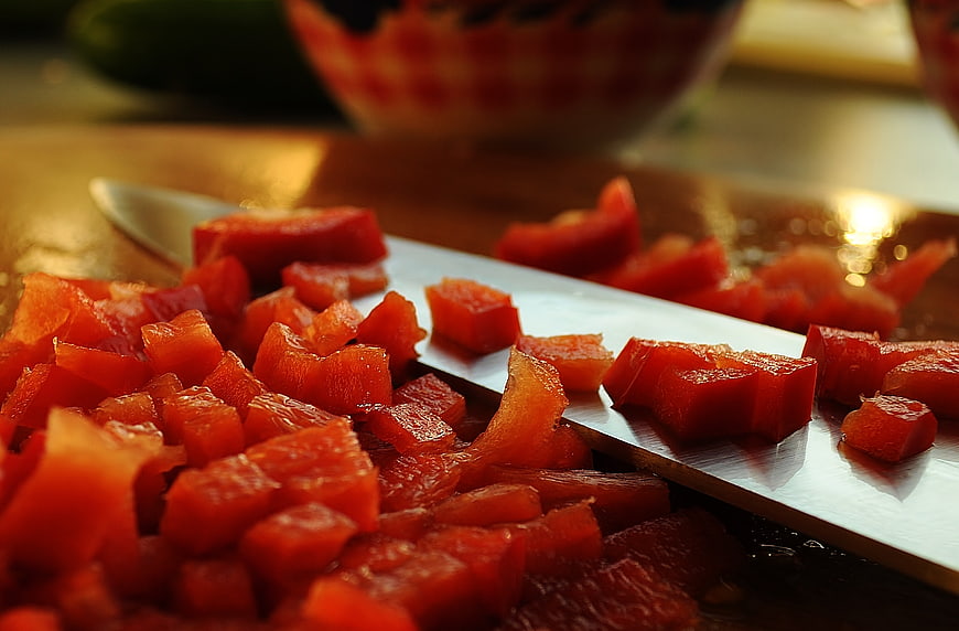 Close-up of diced red peppers on a kitchen knife