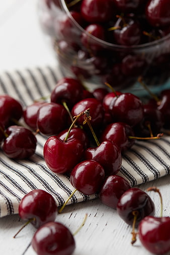 Fresh Red Cherries Spilled on Striped Cloth