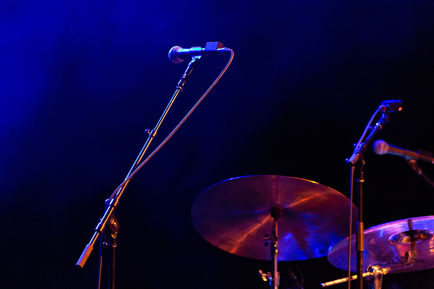 Microphones and Drum Cymbals on Dark Stage with Blue Lighting