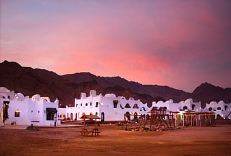 White Desert Resort at Dusk with Pink Sky and Mountains