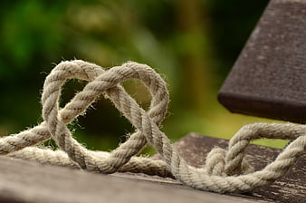 Rope Heart Knot on Wooden Deck with Green Background