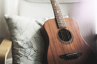 Acoustic Guitar on Chair with Patterned Pillow