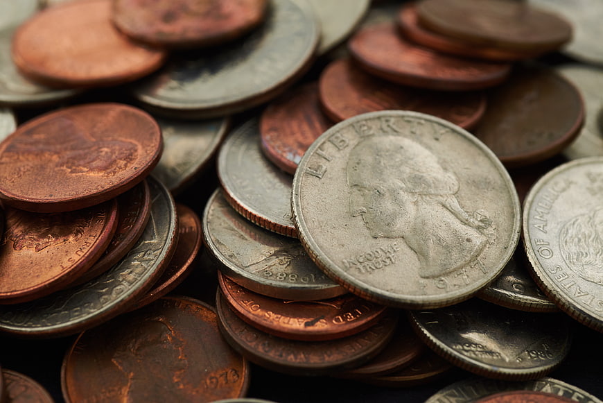 Close-up of mixed US coins including pennies and quarters