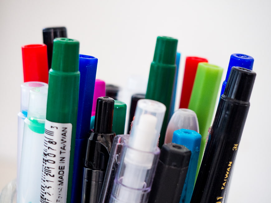 Close-up of colorful markers and pens in a holder