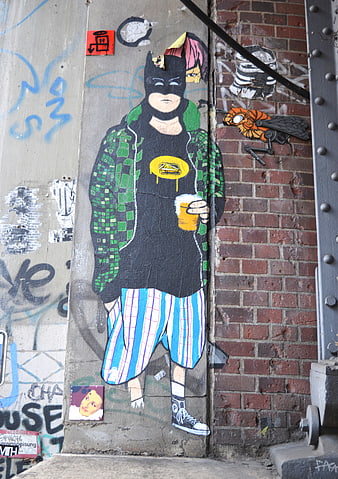 Street art mural of Batman character holding beer on urban wall
