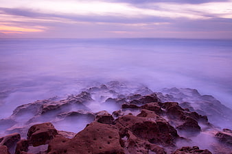 Long Exposure Purple Ocean Waves Crashing on Rocky Coast