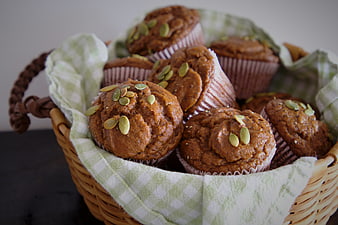 Homemade pumpkin muffins with seeds in a wicker basket