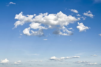 Fluffy white clouds in a bright blue summer sky