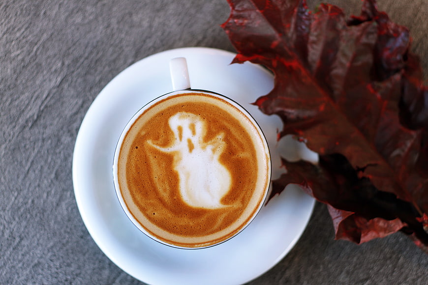 Top view of latte art ghost with autumn leaf
