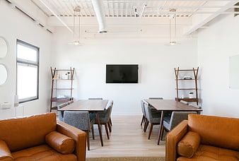 Modern minimalist office lounge with leather sofas and meeting tables