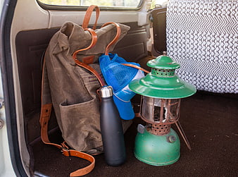 Vintage camping gear in car trunk with backpack and lantern