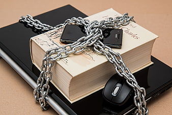 Smartphone and Book Chained Together on Laptop