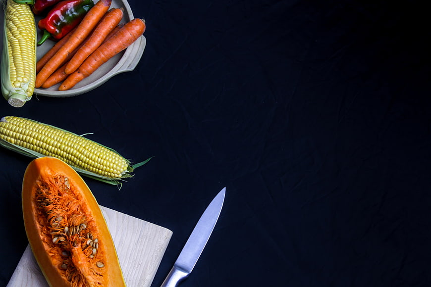 Fresh vegetables and knife on dark background with copyspace