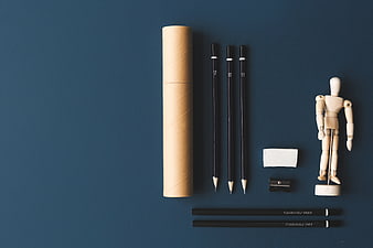 Art supplies flat lay with wooden mannequin on blue background