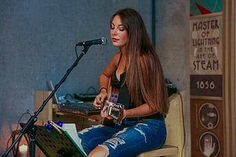 Female Singer Playing Acoustic Guitar in Studio