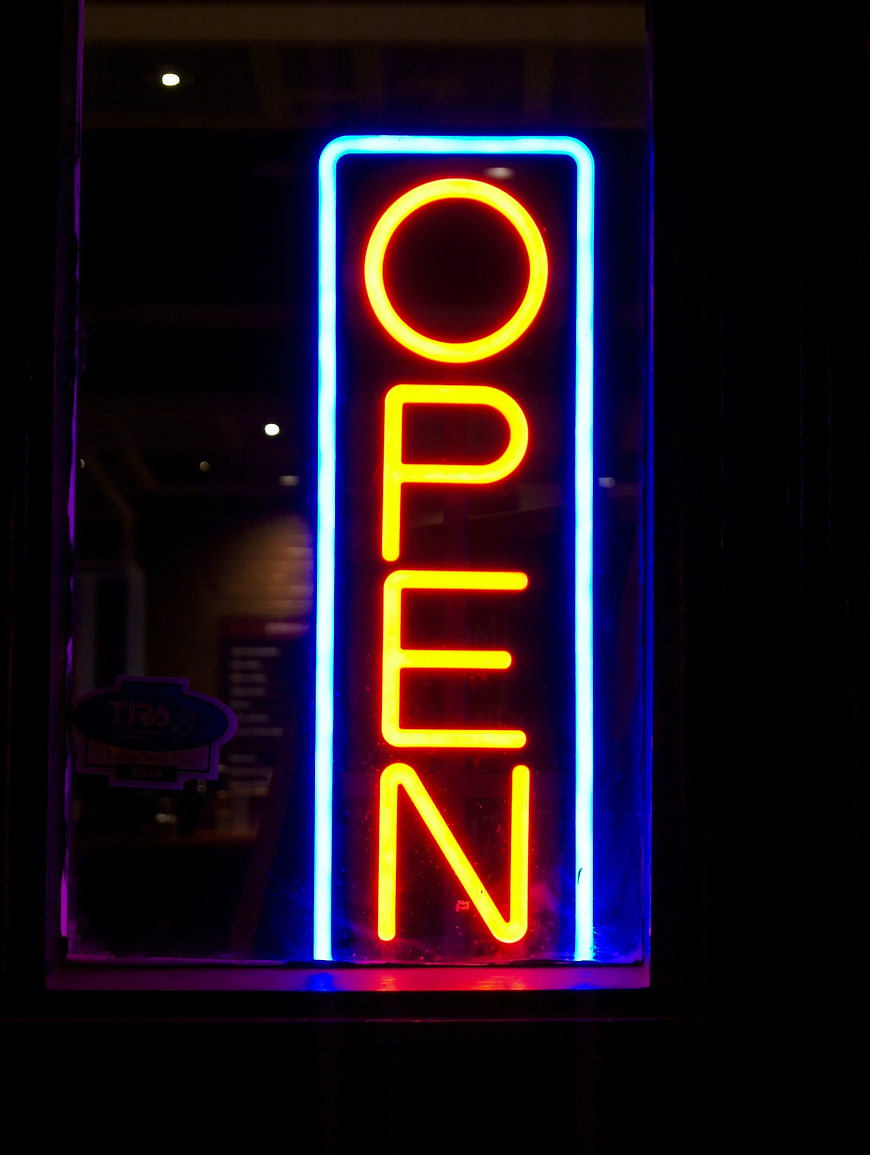 Vertical Neon Open Sign in Window at Night