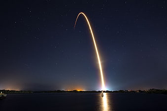 Rocket Launch Light Trail Arcing Over Night Sky