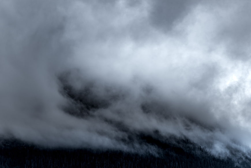 Dramatic Storm Clouds Over Dark Forest Landscape