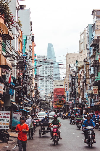 Busy street scene in Ho Chi Minh City with motorbikes and Bitexco Tower
