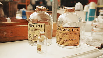 Vintage Glycerine Apothecary Bottles on Wooden Shelf
